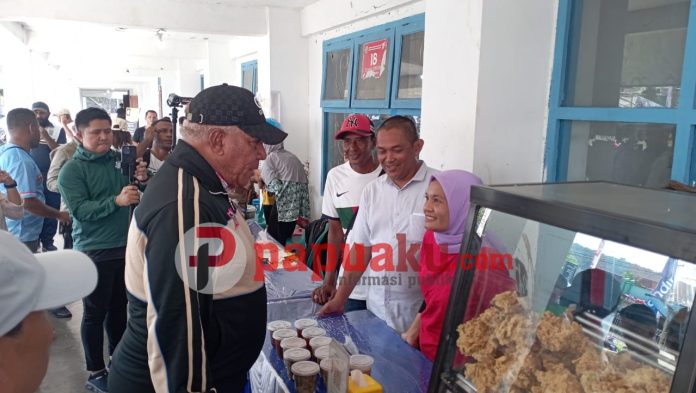 Babe Rochim pemilik ayam geprek sedang melayani Penjabat Gubernur Papua Barat, Komjen Pol (Purn) Drs. Paulus Waterpauw, M.Si yang memborong barang dagangannya. Foto : gos/papuaku.com